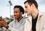 Man showing his friend his cellphone