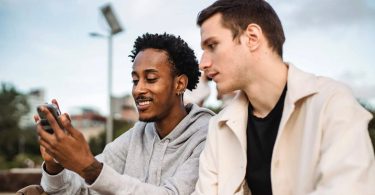 Man showing his friend his cellphone